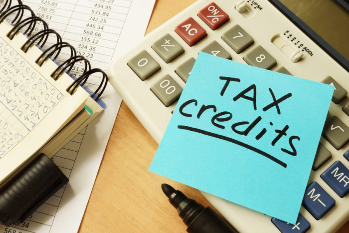 Memo stick with words tax credits. Business concept.